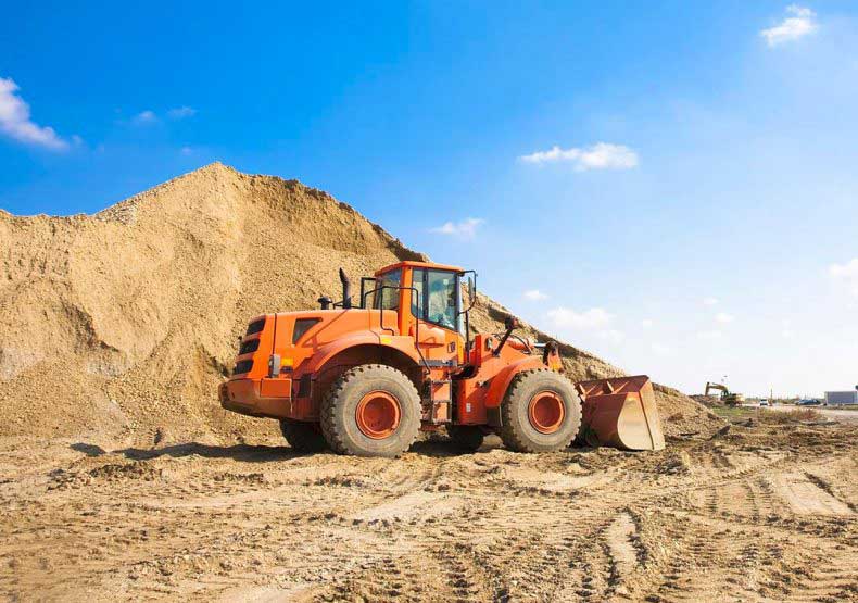 Digger next to pile of dug up dirt